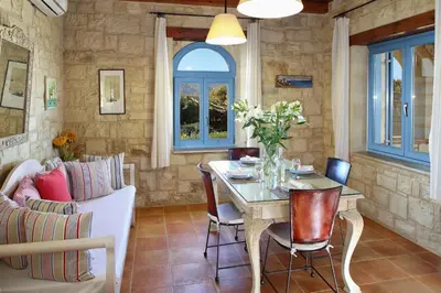 a living room with a table and a couch at Beachfront villa Aqua Marine with private pool,ping-pong & BBQ in Chania Town