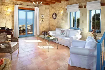 a living room with white couches and a table at Beachfront villa Aqua Marine with private pool,ping-pong & BBQ in Chania Town