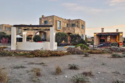 a large house with a gazebo in front of it at Beachfront villa Aqua Marine with private pool,ping-pong & BBQ in Chania Town