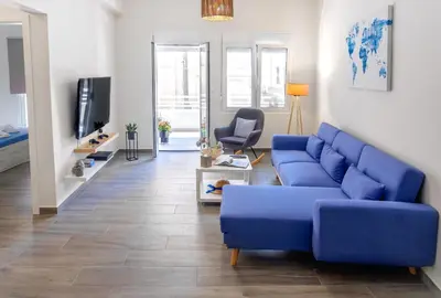 a living room with a blue couch and a tv at Casa In Centro Chania in Chania Town