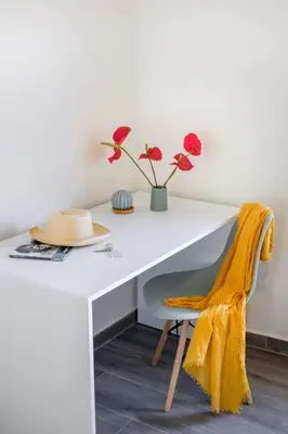 a white desk with a hat and flowers on it at Casa In Centro Chania in Chania Town