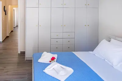 a bedroom with a bed with white cabinets and white towels at Casa In Centro Chania in Chania Town
