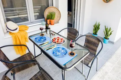 a glass table with two chairs and a bowl of food at Casa In Centro Chania in Chania Town