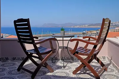 two chairs and a table on a balcony with the ocean at Ariadne Luxury Home in Chania Town