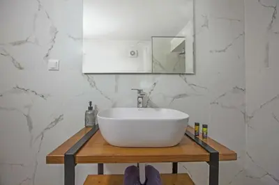 a bathroom with a white sink and a mirror at Ariadne Luxury Home in Chania Town