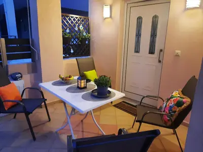 a room with a table and chairs and a door at Pavlos Apartment in Chania Town