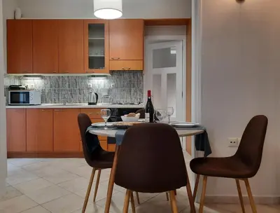 a kitchen with a table with chairs and a bottle of wine at Pavlos Apartment in Chania Town