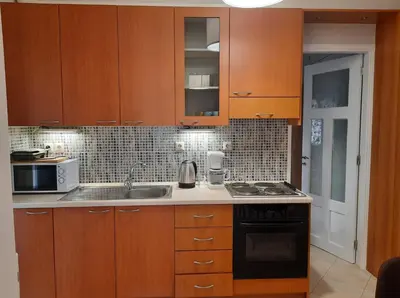 a kitchen with wooden cabinets and a sink at Pavlos Apartment in Chania Town