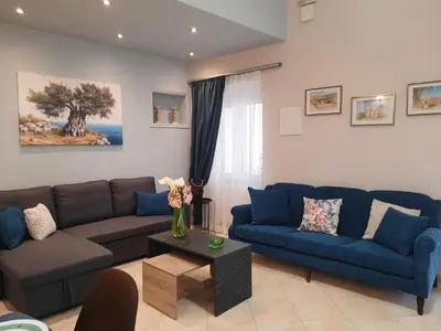 a living room with blue couches and a table at Pavlos Apartment in Chania Town