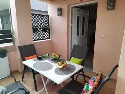 a table and chairs with a bowl of fruit on it at Pavlos Apartment in Chania Town