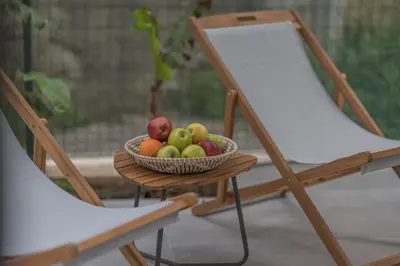 a bowl of fruit on a table next to two chairs at Moka Apartments in Chania Town