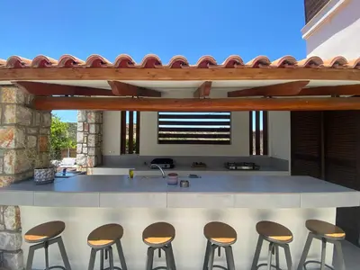 a kitchen with a counter with four stools at Casa Christina-Luxury Villa in Kissamos