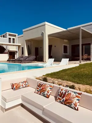 a villa with a swimming pool and a white couch at Bay Overlook Villa in Korakiaí