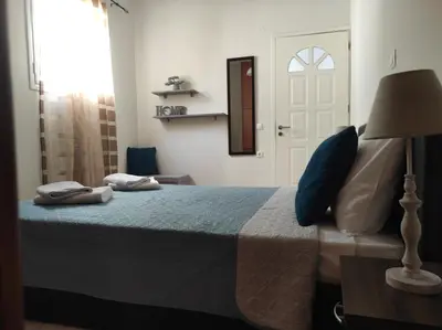 a bedroom with a bed with a lamp and a door at NickTheGreekApartment in Galatás