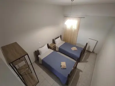 a small bedroom with two beds and a window at NickTheGreekApartment in Galatás