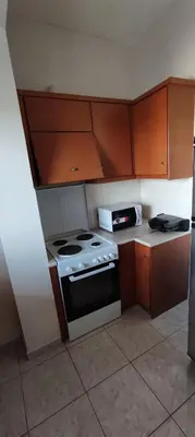 a kitchen with a stove and a microwave at NickTheGreekApartment in Galatás