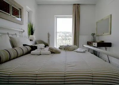 a large bed in a white room with a window at Premium, 2-bedroom Apartment! in Chania Town