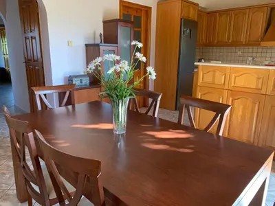 a vase of flowers on a wooden table in a kitchen at VILLA FATIMA in Vryses