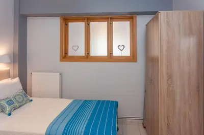 a bedroom with a bed and a window with two hearts on it at Neoria apartment in Chania Town