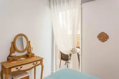 a bedroom with a mirror and a table and a chair at Neoria apartment in Chania Town