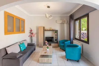 a living room with a couch and blue chairs at Neoria apartment in Chania Town