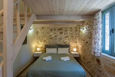 a bedroom with a large bed with two night stands at Casa Athelia: Traditional Home, Local Neighborhood in Chania Town