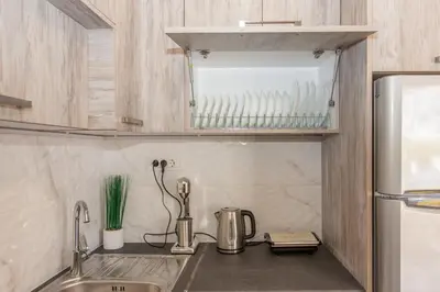 a kitchen counter with a sink and a refrigerator at Casa Athelia: Traditional Home, Local Neighborhood in Chania Town
