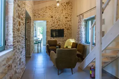 a living room with some chairs and a staircase at Casa Athelia: Traditional Home, Local Neighborhood in Chania Town