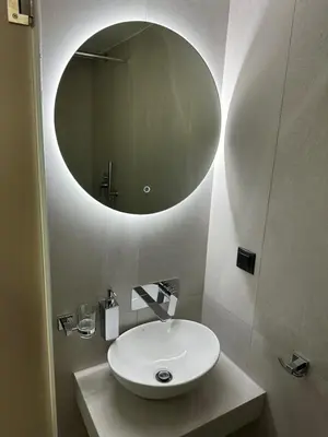 a bathroom with a sink and a round mirror at Electra Studios in Palaiochóra