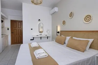 a bedroom with a large white bed with towels on it at Electra Studios in Palaiochóra