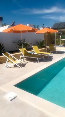 a group of chairs and umbrellas next to a swimming pool at Katikies Savrani in Perivólia