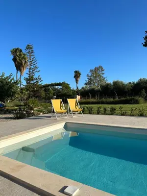 a swimming pool with two yellow chairs next to it at Katikies Savrani in Perivólia