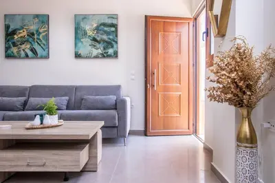 a living room with a couch and a table and a door at Luxury Katsoulakis Apartments in countryside in Alikianós