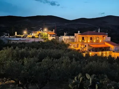 a house sitting on top of a hill at night at Aloni Studio in Azoyirás