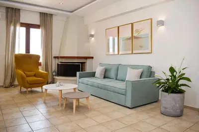a living room with a blue couch and a chair at Rastoni Chania - Guests Apartment in Chania Town