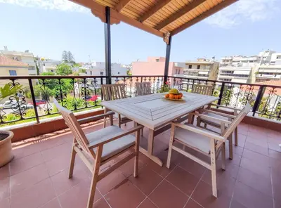 a wooden table and chairs on a balcony with a view at Rastoni Chania - Guests Apartment in Chania Town