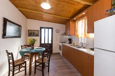 a kitchen with a table and chairs and a refrigerator at Villa Margarita's farm, private pool in Maláthiros