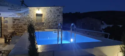 a swimming pool in front of a building at night at Villa Margarita's farm, private pool in Maláthiros