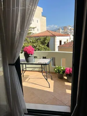a view of a balcony with a table and flowers at Antonis Kavros appartment in the center of chania in Chania Town