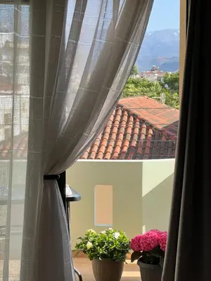 two potted plants sitting on a window sill with curtains at Antonis Kavros appartment in the center of chania in Chania Town