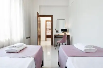 a room with two beds and a desk with a chair at Chania Boutique Villa - steps from the beach in Chania Town