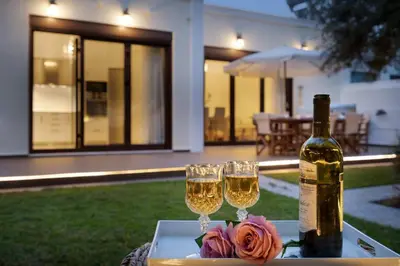 a table with two glasses of wine and a rose at Chania Boutique Villa - steps from the beach in Chania Town