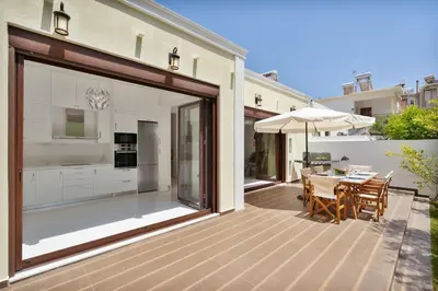 an outdoor deck with a table and an umbrella at Chania Boutique Villa - steps from the beach in Chania Town