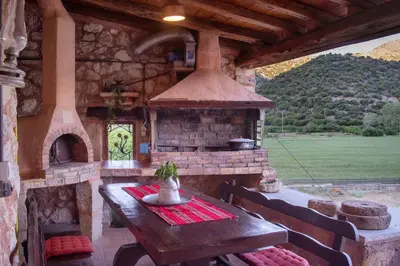 an outdoor kitchen with a table and an oven at villa archontiko ASKYFOU SFAKIA in Karés