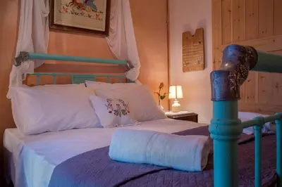 a bedroom with a bed with a blue and white bedspread at villa archontiko ASKYFOU SFAKIA in Karés
