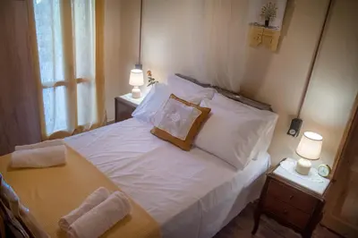 a bedroom with a bed with white sheets and pillows at villa archontiko ASKYFOU SFAKIA in Karés