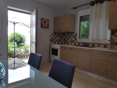 a kitchen with blue chairs and a table and a window at Xenia's countryside guesthouse in Agia Marina Nea Kydonias
