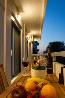 a table with fruit and wine glasses on a balcony at koukounari apartment in Chania city center in Chania Town