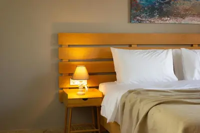 a bed with a nightstand with a lamp on it at koukounari apartment in Chania city center in Chania Town