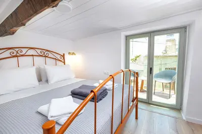 a bedroom with a bed and a balcony at Mansion Fabrica in Kalleryianá